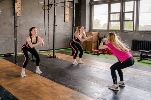 three ladies exercise class squats