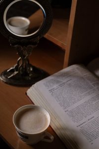 Hot drink next to book on wooden table