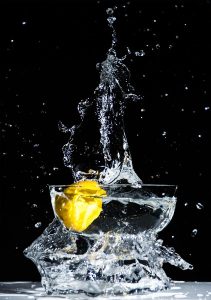 Lemon splashing into vodka glass