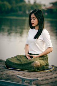 Woman meditating by water